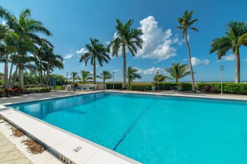 a swimming pool with palm trees in the background at Admiralty House 1705S in Marco Island