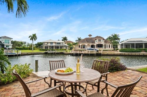 a patio with a table and chairs next to a body of water at Manatee Manor in Marco Island