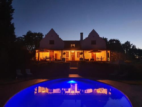 a house with a blue pool in front of a house at Vredenburg Manor House in Somerset West