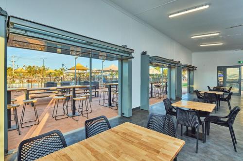 a restaurant with tables and chairs and a patio at RAC Exmouth Cape Holiday Park in Exmouth