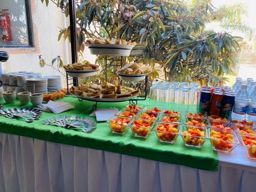 a table with a buffet of fruit and drinks at Hotel La Mansión in San José Iturbide