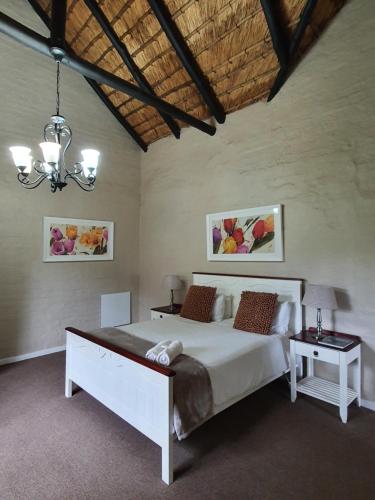 a bedroom with a large bed and two tables at Invermooi Estate in Nottingham Road