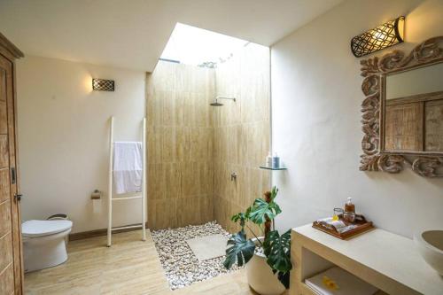 La salle de bains est pourvue d'une douche, de toilettes et d'un lavabo. dans l'établissement 2 BR Villa with open view of rice paddies & sunset, à Gianyar