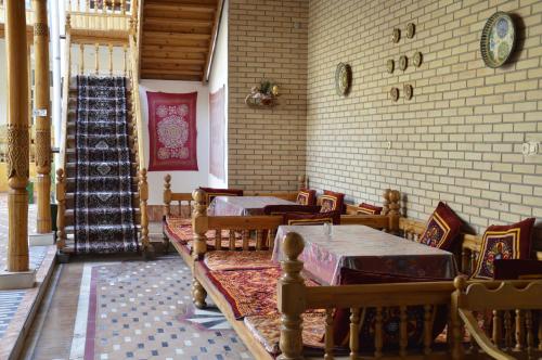 a restaurant with tables and chairs and a staircase at Guest House Marokand in Samarkand