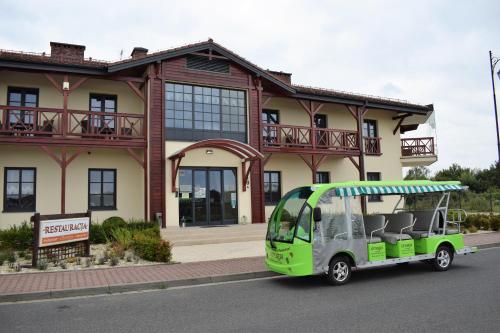 a green vehicle parked in front of a building at Boutique Odyseja & Spa in Ciechocinek