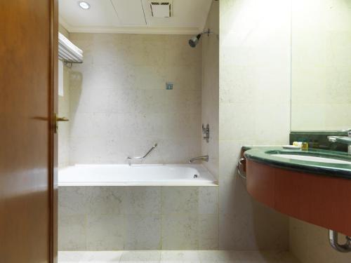 a bathroom with a bath tub and a sink at Monarch Plaza Hotel in Taoyuan