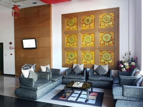 a living room with couches and a wall with a window at 2 Inn 1 Boutique Hotel & Spa in Sandakan