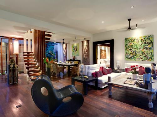 a living room with a couch and a chair at Majapahit Beach Villas by Nakula in Ketewel