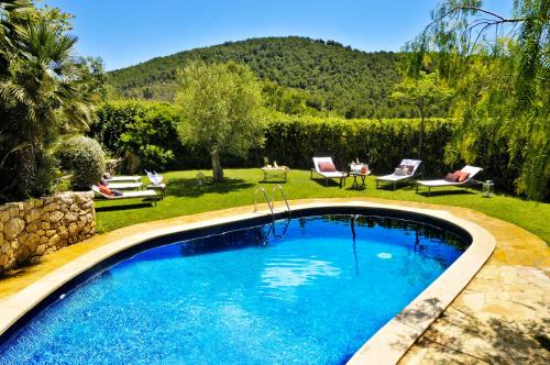 een zwembad in een tuin met stoelen en een tafel bij Masía Cal Simó empresas, retiros, familias,amigos,celebraciones,eventos,bodas in Canyelles