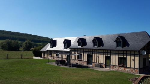 una grande casa con tetto di gambero su un campo di La Longère Des Nuits De Varenne a Muchedent