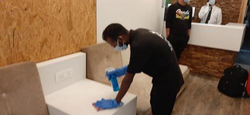 a woman with a mask and blue gloves working on a box at Hotel Amisha International in Surat