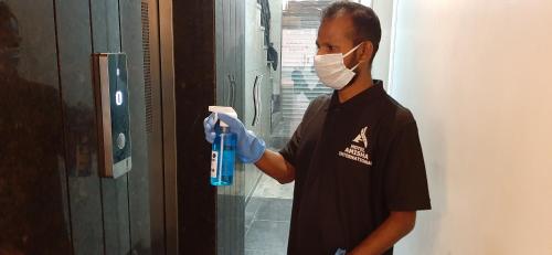 a man wearing a mask and gloves holding a tool at Hotel Amisha International in Surat