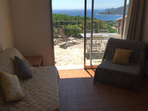 a living room with a couch and a view of a patio at Les Mini-Villas de Santa Giulia in Porto-Vecchio