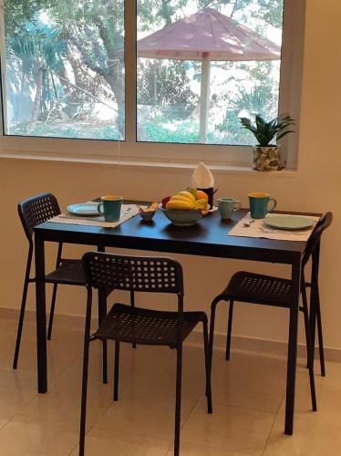 a table with two chairs and a bowl of fruit on it at Sea and Sun in Amoudara Herakliou