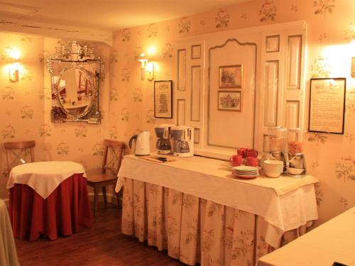 a dining room with a table and two tables with dishes at Le Château D'Osthoffen in Osthoffen