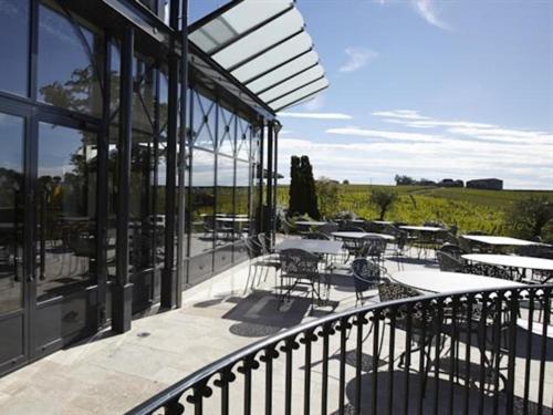 een balkon van een gebouw met tafels en stoelen bij Château La Rose Perrière in Lussac