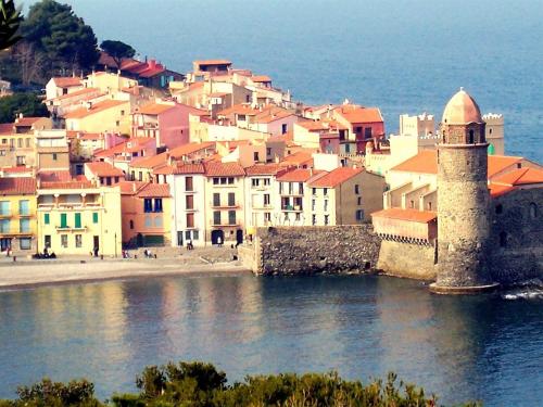 un grupo de edificios en una colina junto al agua en Château d'Ortaffa, en Ortaffa