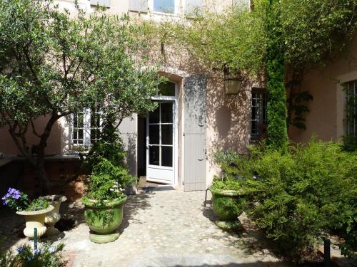 una casa con una puerta blanca y algunas plantas en Château d'Ortaffa, en Ortaffa