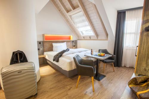 レーゲンスドルフにあるBoutiquehotel Thessoni Classic & Self service Residence Home Zürichのベッドとテーブルと椅子のある寝室
