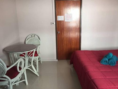 a room with a bed and a table and chairs at SMILE HOME GUESTHOUSE in Rayong
