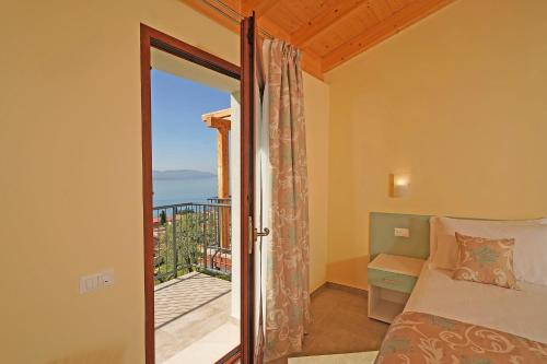 a bedroom with a bed and a view of the ocean at Residence Dany appartamenti con cucina vista lago piscina e parcheggio in Gargnano