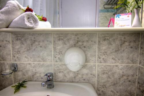 baño con lavabo y estante con toallas en Solimar Dias Hotel, en Adelianos Kampos