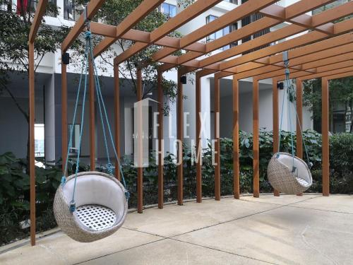 two hanging baskets are hanging from a wooden structure at Spacious Big Room, Designed & Quiet Family Home, Eclipse in Cyberjaya by Flexihome-MY in Cyberjaya