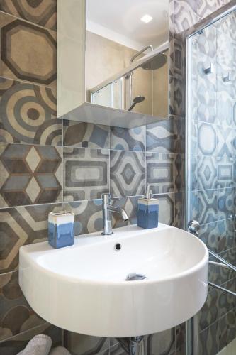 a bathroom with a white sink and a mirror at Casa Vacanza Noban - CaseSicule in Ispica