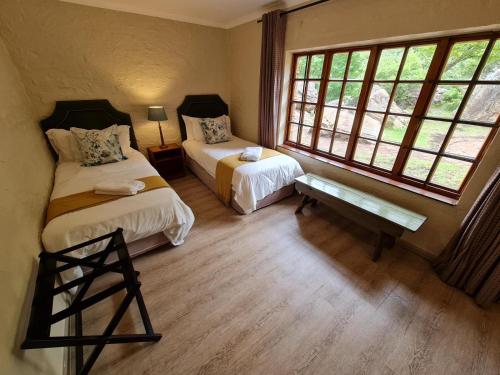 a room with two beds and a window at Migrate Portfolio in Dullstroom