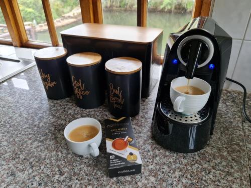 a coffee maker and two cups of coffee on a counter at Migrate Portfolio in Dullstroom