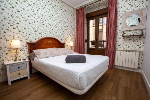 um pequeno quarto com uma cama e uma janela em Pensión Amaiur em San Sebastián