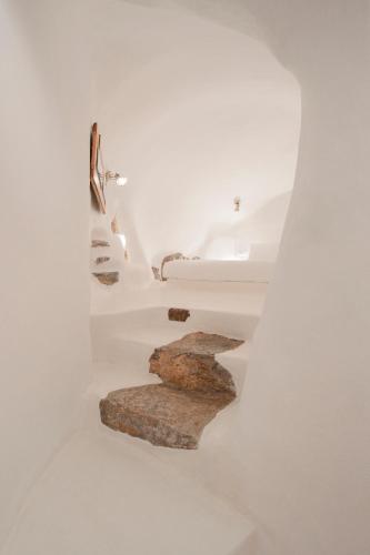 a staircase in a white room with rocks at Nano Suites in Éxo Goniá