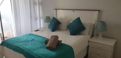 un dormitorio con una cama con un animal de peluche en Dumela Margate Flat No 18, en Margate