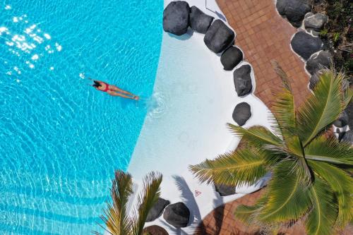 eine Luftansicht einer Person in einem Kanu im Wasser in der Unterkunft Drago Residence by Upper Luxury Housing - Parque Santiago in Playa de las Americas