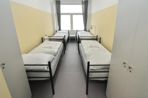 - une rangée de lits dans une chambre avec fenêtre dans l'établissement Hostel Tereza Břeclav, à Břeclav