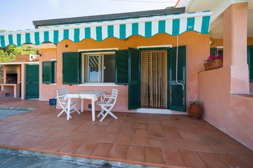 a patio with a table and chairs on a house at Appartamenti Vista Mare - Goelba in Capoliveri