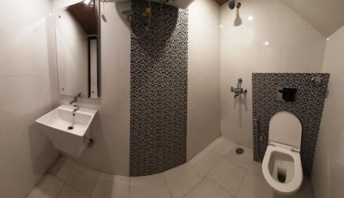 a bathroom with a toilet and a sink at Hotel Lords Regency in Shimla