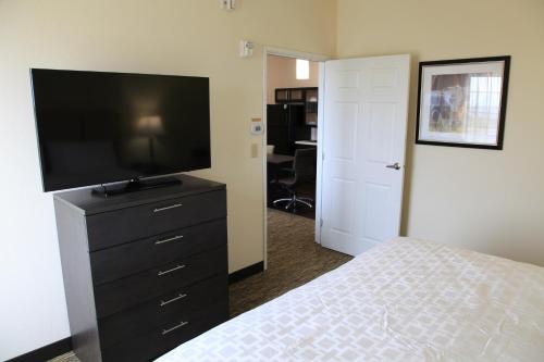 a bedroom with a bed and a flat screen tv at Candlewood Suites - Austin North by IHG in Austin