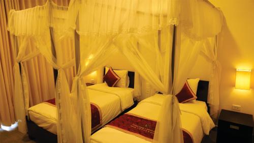 Un pat sau paturi într-o cameră la Sài Gòn - Bản Giốc Resort