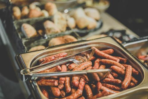 a bunch of sausages in trays on a table at Central Inn in Zlatibor