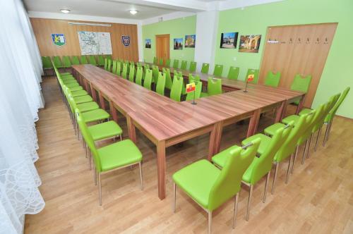 a conference room with a long wooden table and green chairs at Hostel Tereza Břeclav in Břeclav