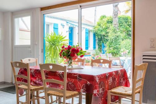 une table de salle à manger avec un vase de fleurs dessus dans l'établissement Les Volets Bleus, à Pornic