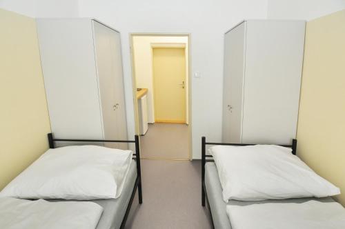 two beds in a room with a hallway at Hostel Tereza Břeclav in Břeclav
