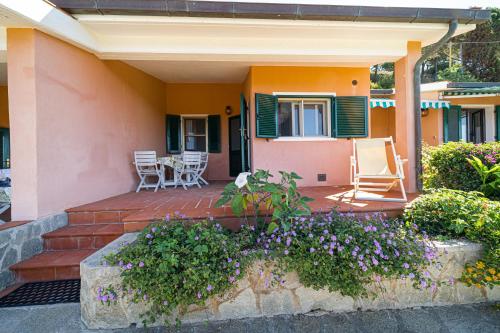 a house with a patio and flowers in front of it at Appartamenti Vista Mare - Goelba in Capoliveri
