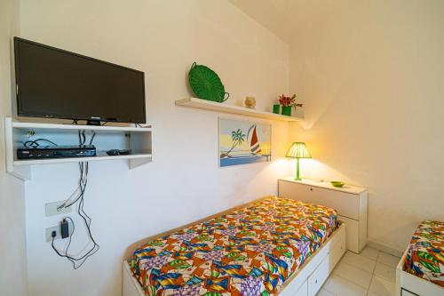 a bedroom with a bed and a flat screen tv at Appartamenti Vista Mare - Goelba in Capoliveri
