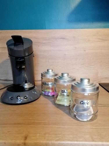 une cafetière et quatre bocaux en verre sur une table dans l'établissement Au pied des remparts ..., à Boulogne-sur-Mer