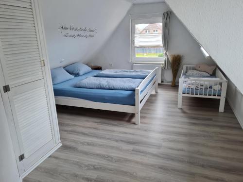 ノルデンにあるWohnung Nordseebrieseのベッドルーム1室(青いシーツと窓付)