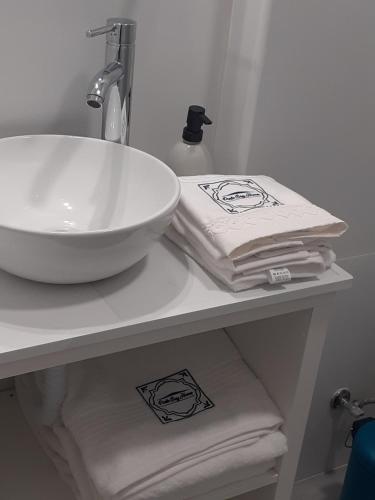 a bathroom counter with a sink and towels on it at Porto Beach Rooms in Porto