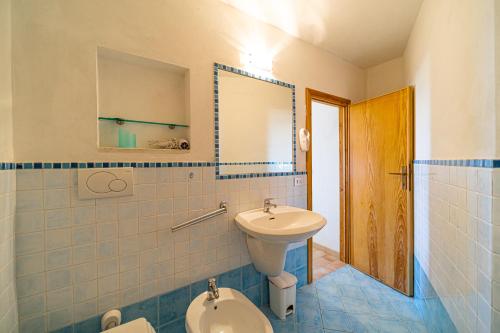 a bathroom with a sink and a toilet and a mirror at Appartamenti Vista Mare - Goelba in Capoliveri