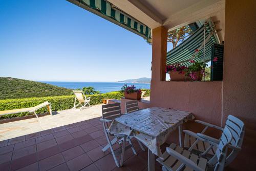 a table and chairs on a porch with a view of the ocean at Appartamenti Vista Mare - Goelba in Capoliveri
